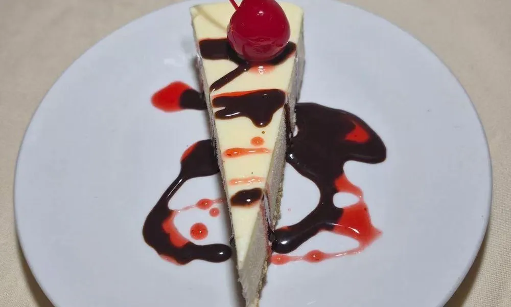 Cheesecake Creamy cheesecake topped with cherry and chocolate sauce at Bamboo Cafe, a Chinese Restaurant restaurant in Glendale